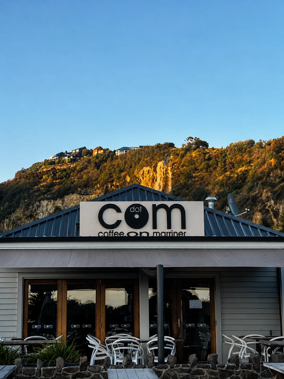 Dot Com Cafe exterior beneath the sunlit Sumner hillside