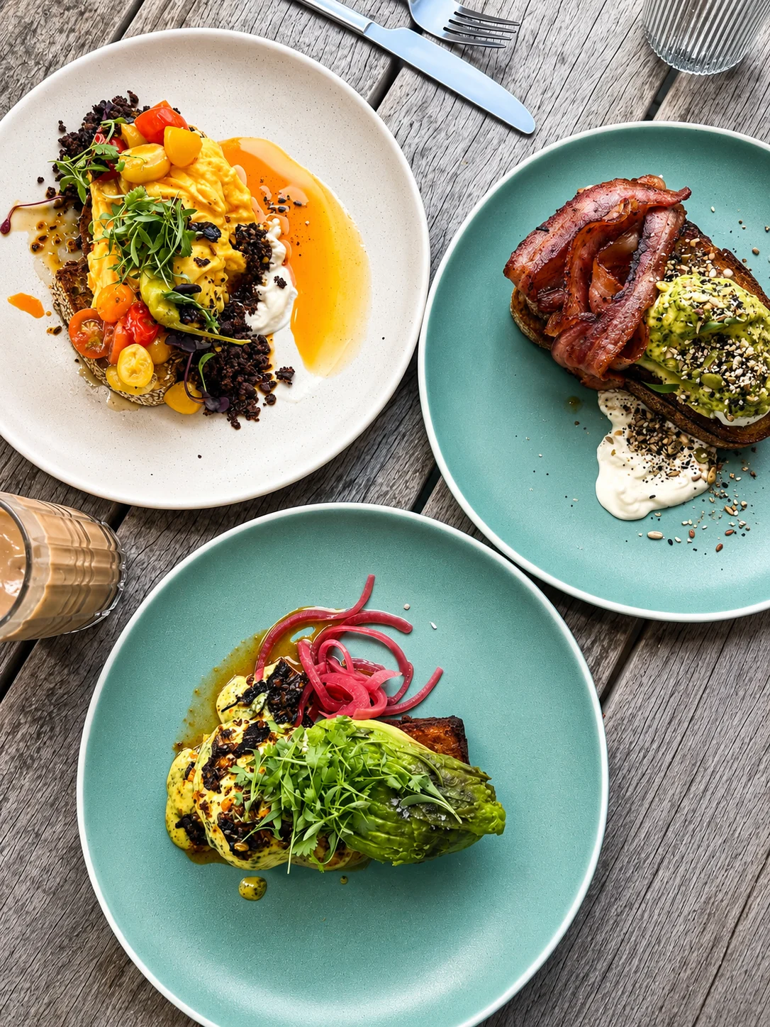 Three colourful brunch plates served outdoors