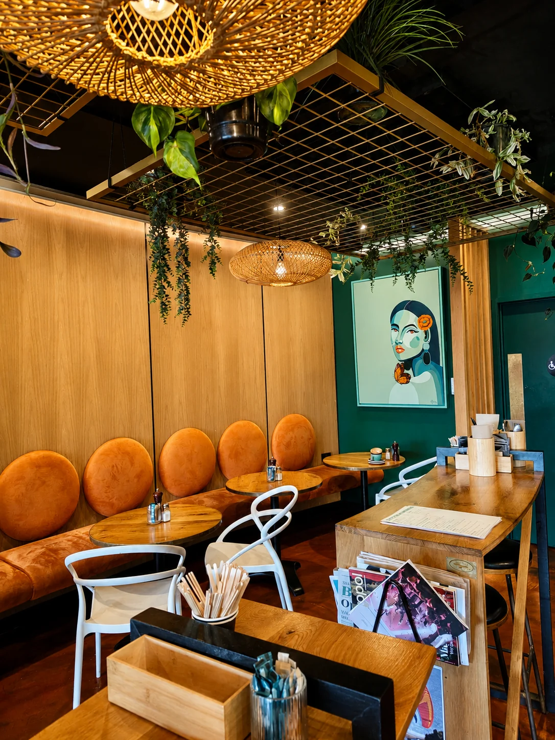Dot Com Cafe seating beneath woven lights and hanging greenery