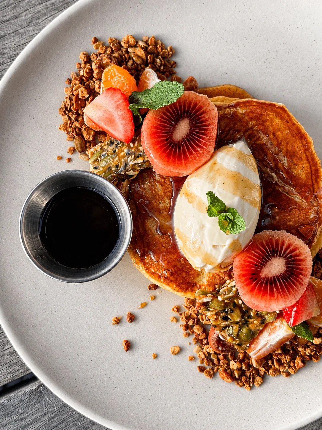 Pumpkin Pie Pancakes with winter fruit, granola and maple syrup